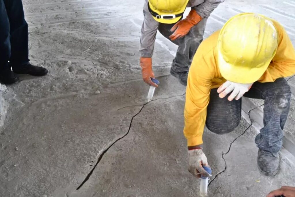 two contractors repairing concrete wide cracks