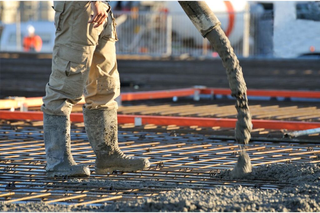 a man laying concrete on construction site