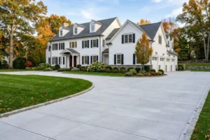 Newly poured concrete driveway in front of a luxury home in Fairfield County, CT, showcasing a smooth finish and professional installation.